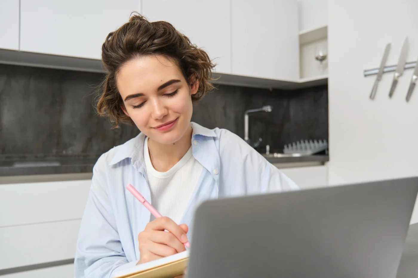 Profesional toma notas frente a un laptop en el curso de psicología forense