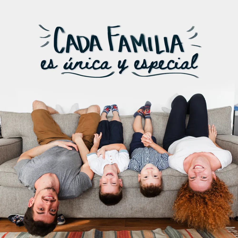Familia reconstituida recostada en el sofá sonriendo, fotografiada desde arriba