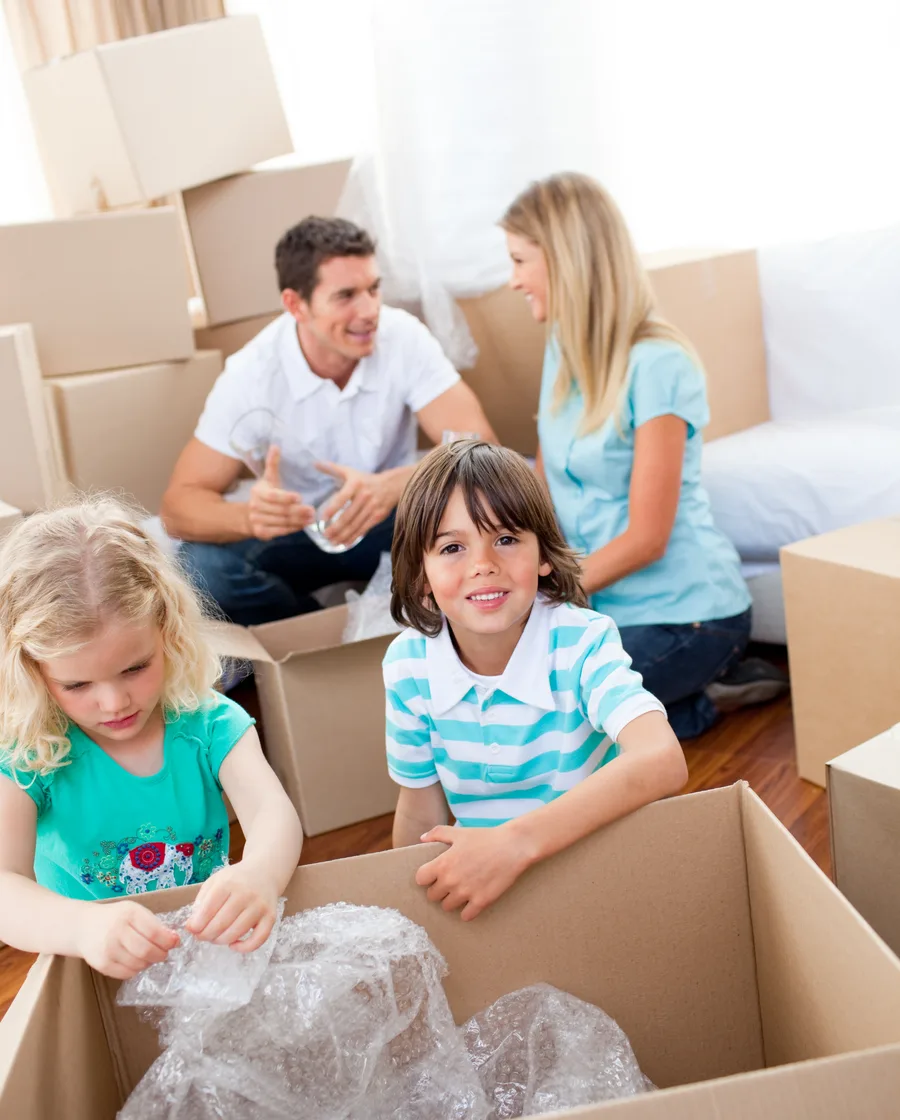 Familia con dos niños desempaca cajas en su nueva casa, el comienzo de una familia reconstituida